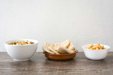 Hummus in bowl on rustic woodの写真素材