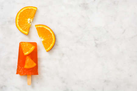 Homemade orange popsicle on marbleの写真素材