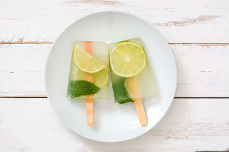 Lime popsicles on white wooden tableの写真素材