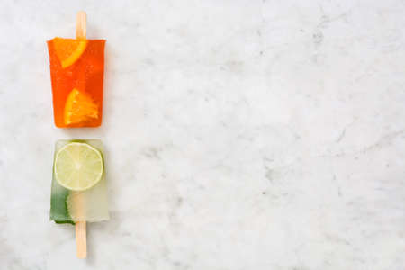 Orange and lime popsicle popsicle on marbleの写真素材