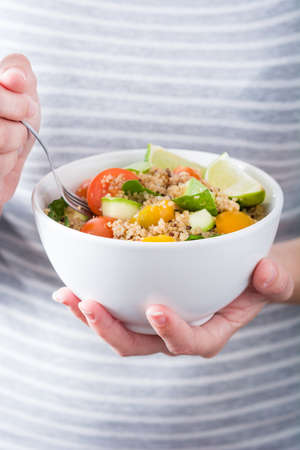 Woman eating quinoa and vegetablesの写真素材