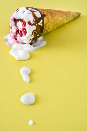 Strawberry ice cream cone on yellow backgroundの写真素材
