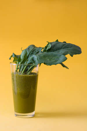 Healthy green detox with spinach, cucumber, lime and apples on a rustic on yellow backgroundの写真素材