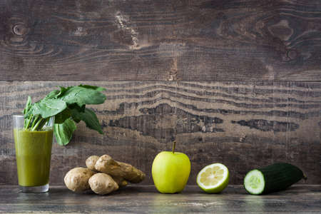 Healthy green detox with spinach, cucumber, lime and apples on a rustic wooden tableの写真素材