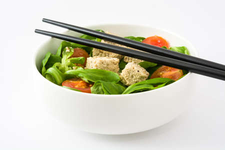 Vegan tofu salad with tomatoes and lamb's lettuce isolated on white backgroundの写真素材