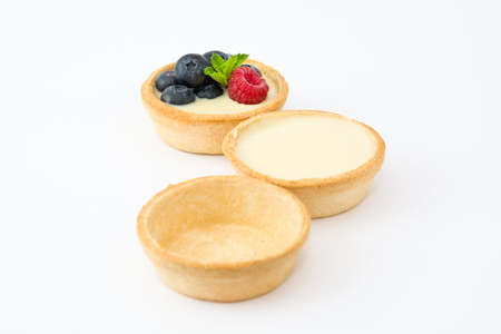 Delicious tartlets with raspberries and blueberries isolated on white backgroundの写真素材