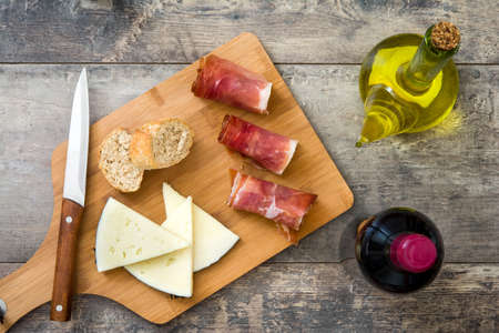 Spanish serrano ham, cheese and sausage on a rustic wooden backgroundの写真素材