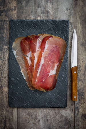 Spanish serrano ham on cutting board slateの写真素材