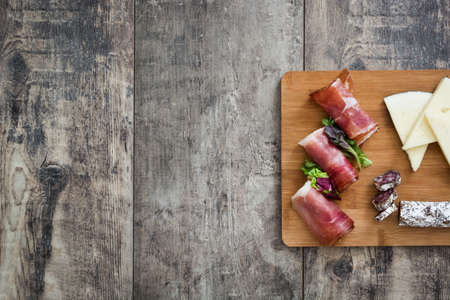 Spanish serrano ham, cheese and sausage on a rustic wooden backgroundの写真素材