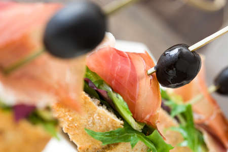 Spanish serrano ham skewer with olive and lettuceの写真素材