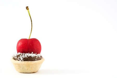 Delicious chocolate tartlet with cherry and coconut isolated on white backgroundの写真素材