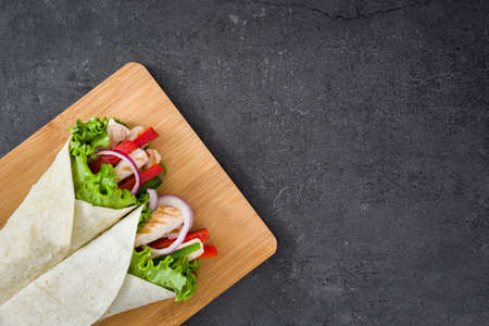 Mexican chicken fajitas with peppers lettuce and onion on slate backgroundの写真素材
