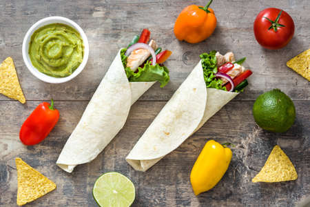 Mexican chicken fajita and ingrendients on a rustic wooden backgroundの写真素材