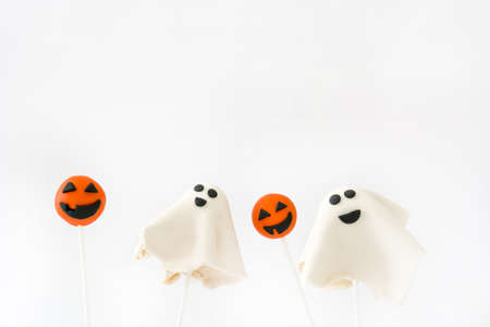 With Halloween cake pops phantom and pumpkin shape isolated on white background