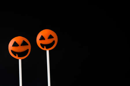 Halloween cake pops with pumpkin shape on black backgroundの写真素材