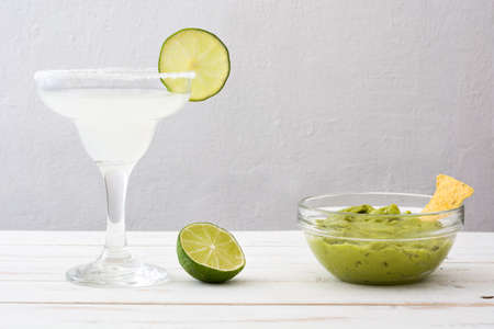Margarita cocktail and guacamole on a white wooden tableの写真素材