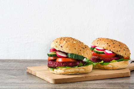 Veggie burgers beet on a rustic wooden table and white wallの写真素材