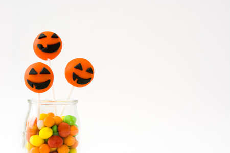 Halloween cake pops and colored candies isolated on white backgroundの写真素材