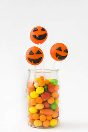 Halloween cake pops and colored candies isolated on white backgroundの写真素材