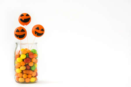 Halloween cake pops and colored candies isolated on white backgroundの写真素材