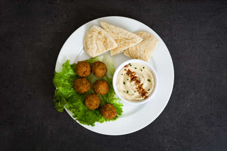 Vegetarian falafels, hummus and pita bread on slate backgroundの写真素材
