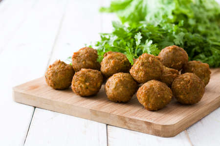 Vegetarian falafels and lettuce on white wooden table