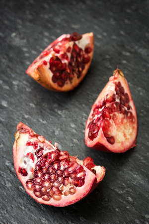 Pomegranate fruit on slate backgroundの写真素材