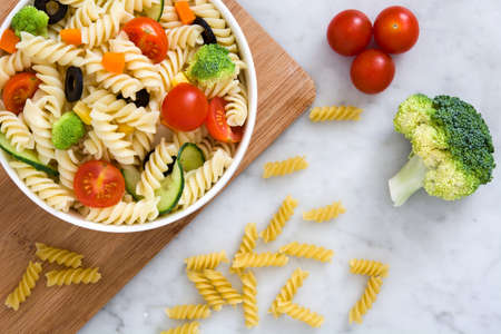 Pasta salad in a bowl on white marbleの写真素材