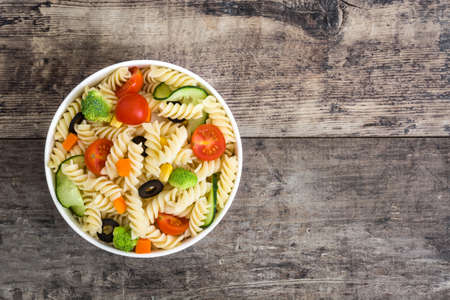 Pasta salad in bowl on rustic woodの写真素材