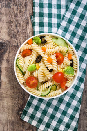 Pasta salad in bowl on rustic woodの写真素材
