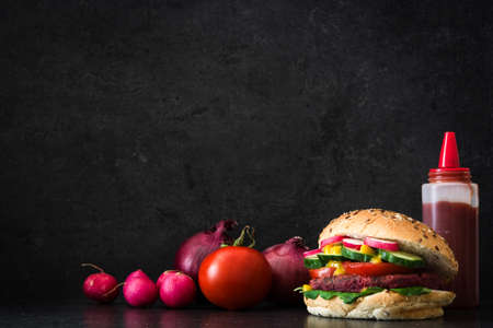 Veggie burger beet and vegetables on black slate backgroundの写真素材