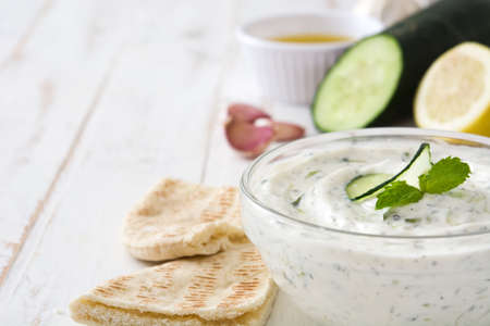 Tzatziki in bowl on white wooden tableの写真素材