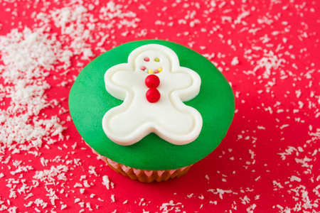 Gingerbread man cupcake on red backgroundの写真素材