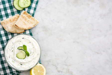 Tzatziki sauce and ingredients on white marbleの写真素材