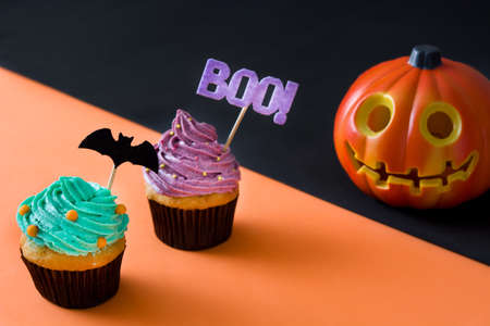 Halloween cupcakes and pumpkin on Halloween black and orange backgroundの写真素材