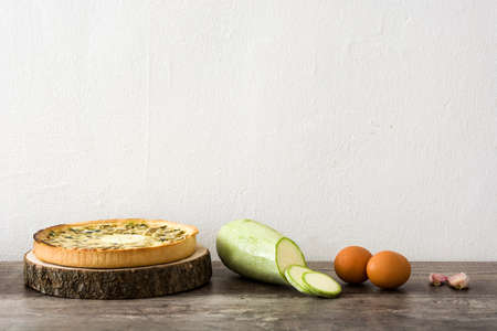 French quiche with vegetables on a rustic wooden tableの写真素材