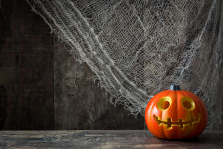 Halloween pumpkin and cobweb on rustic wooden tableの写真素材