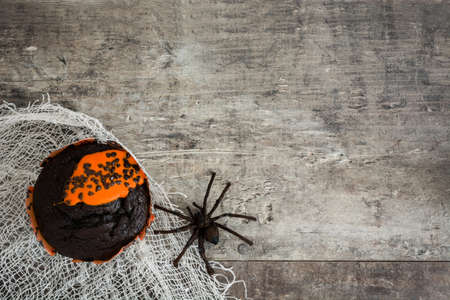 Halloween muffin and a spider on rustic wooden backgroundの写真素材