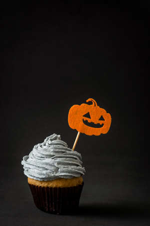 Halloween cupcake with pumpkin on black backgroundの写真素材
