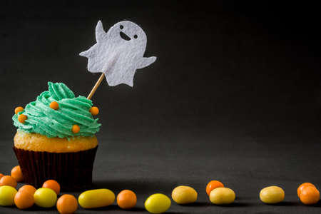 With cupcake Halloween ghost and candies on black backgroundの写真素材