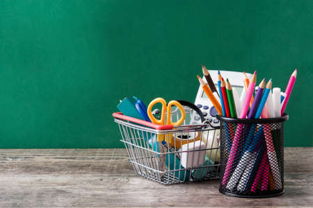 School supplies on a wooden table and blackboard backgroundの写真素材