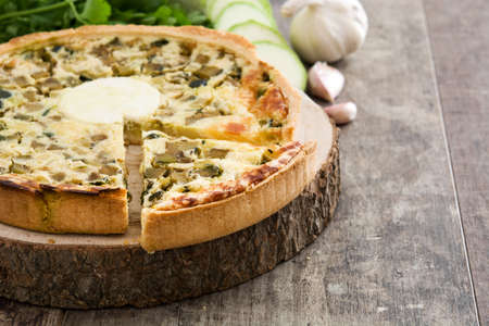 French quiche Lorraine with vegetables on a rustic wooden tableの写真素材