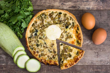 French quiche with vegetables on a rustic wooden tableの写真素材