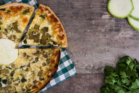 French quiche Lorraine with vegetables on a rustic wooden tableの写真素材