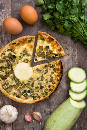 French quiche Lorraine with vegetables on a rustic wooden tableの写真素材