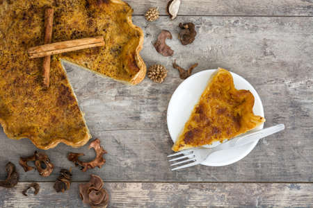 Homemade pumpkin pie on a rustic wooden backgroundの写真素材