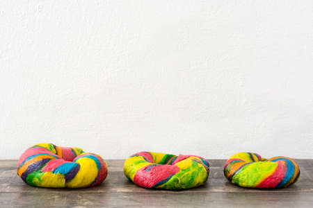 Colorful bagels on a wooden tableの写真素材