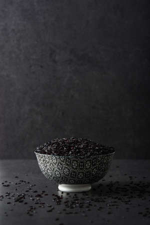 Black rice in a bowl on black backgroundの写真素材