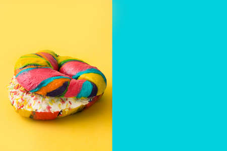 Colorful bagel on yellow and blue backgroundの写真素材