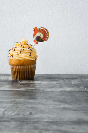 Thanksgiving cupcake on wooden table and white wallの写真素材